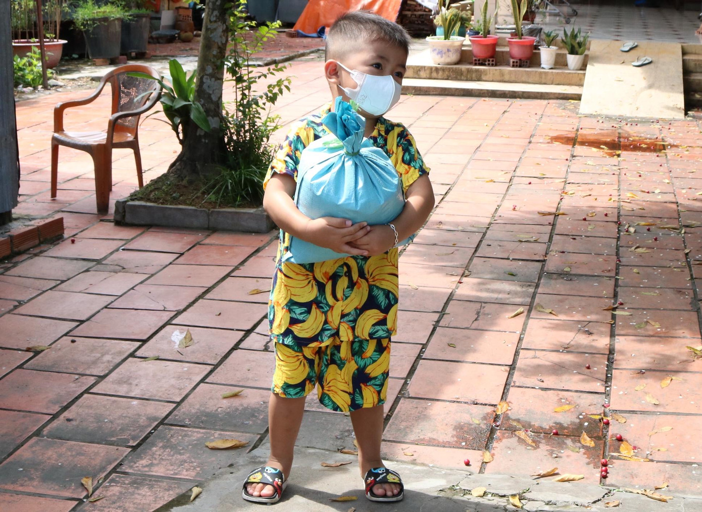 Bé trai nhanh nhảu chạy ra nhận quà của chú công an - Ảnh: Kim Hà.