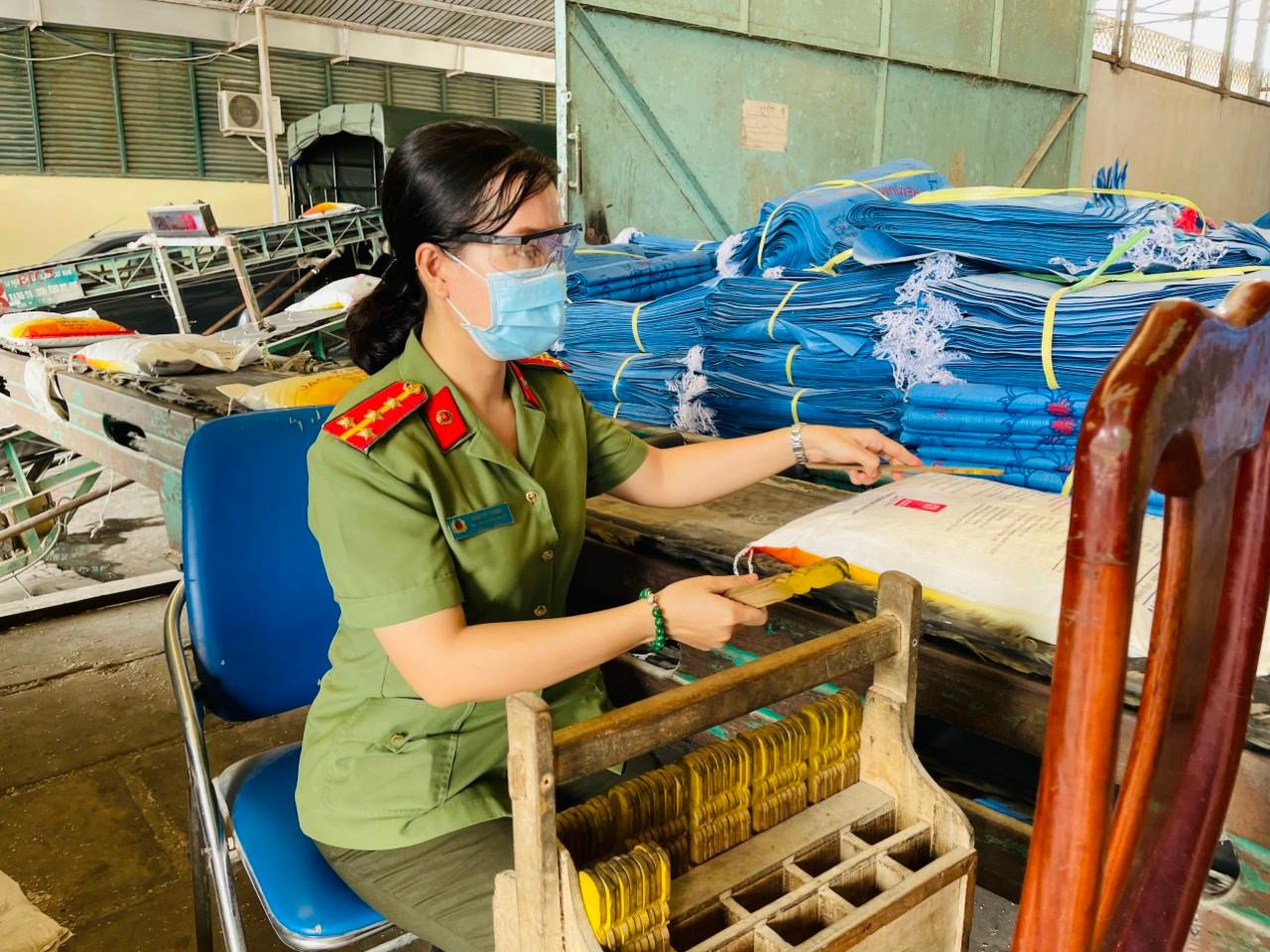 Một nữ đại uý Công an tỉnh An Giang đang trực tiếp nhận gạo.