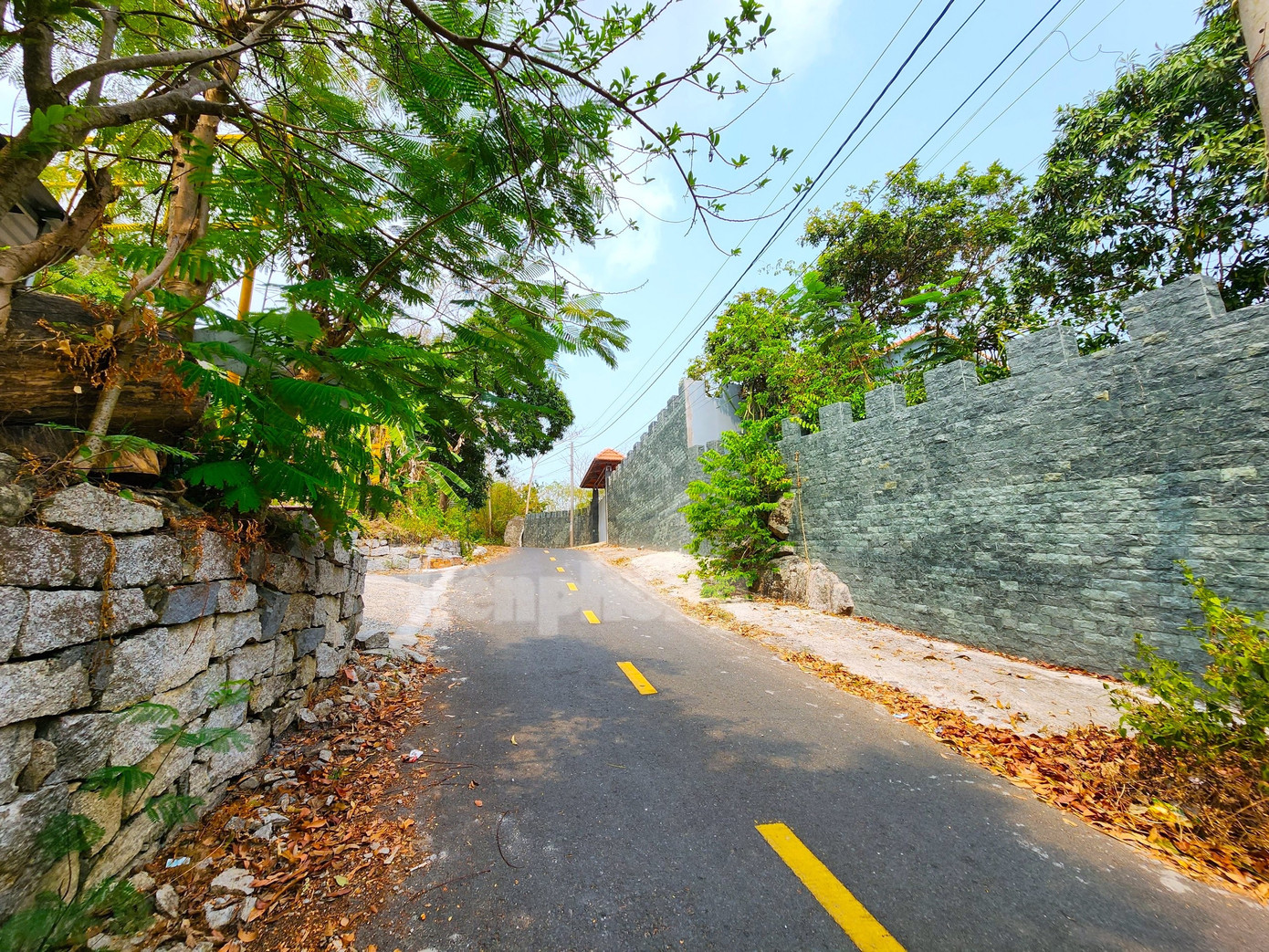 Căn nhà của ông P. được che chắn bằng bờ tường đá cao khoảng 2m. Một lãnh đạo địa phương cho biết, nhà ông này luôn luôn đóng cửa, người bên ngoài khó nhìn thấy được bên trong. Ảnh: Kim Hà.