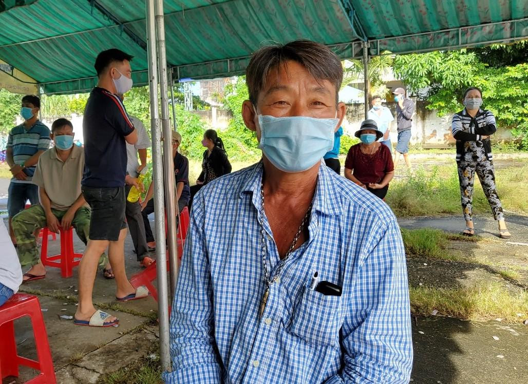 Ông Trần Văn O ngồi chờ lấy phiếu sau khi tiêm. Ảnh: Kim Hà.