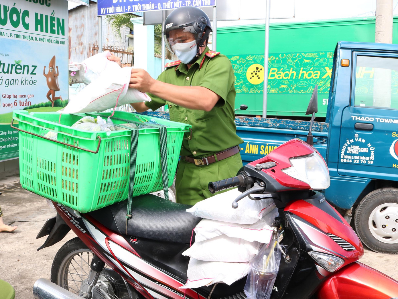 Thượng uý Thái Huyền Di - Cán bộ Công an phường Thới Thuận trở thành shipper mang thực phẩm đến cho người dân trong ngày Lễ Quốc Khánh - Ảnh: Kim Hà.