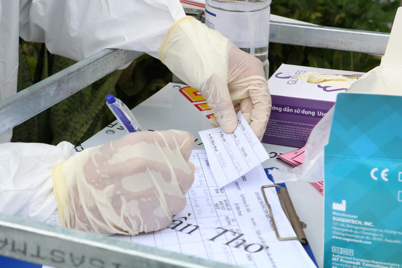 Nhân viên y tế phường Trà Nóc, quận Bình Thuỷ ghi thông tin người được lấy mẫu - Ảnh: Kim Hà.