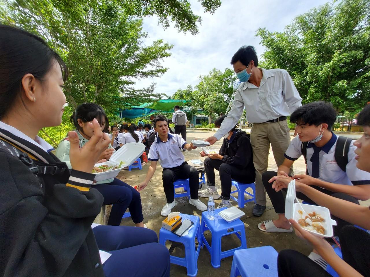 Các sĩ tử phấn khởi nhận cơm từ giáo viên của trường - Ảnh: Kim Hà.