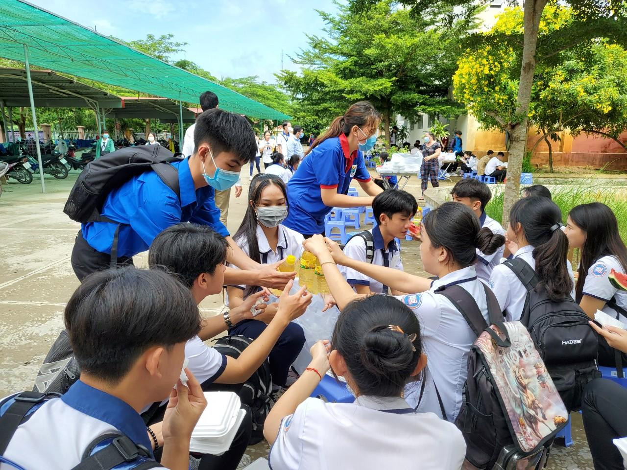 Các tình nguyện viên còn phát thêm nước cho các thí sinh sau bữa ăn - Ảnh: Kim Hà.