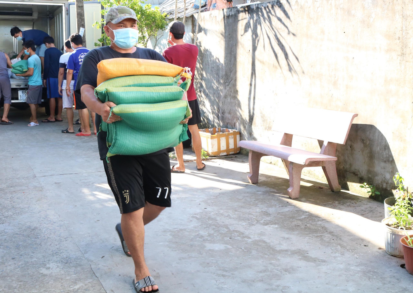 Vận chuyển gạo từ xe tải để chuẩn bị trao cho người dân xóm trọ - Ảnh: Kim Hà.