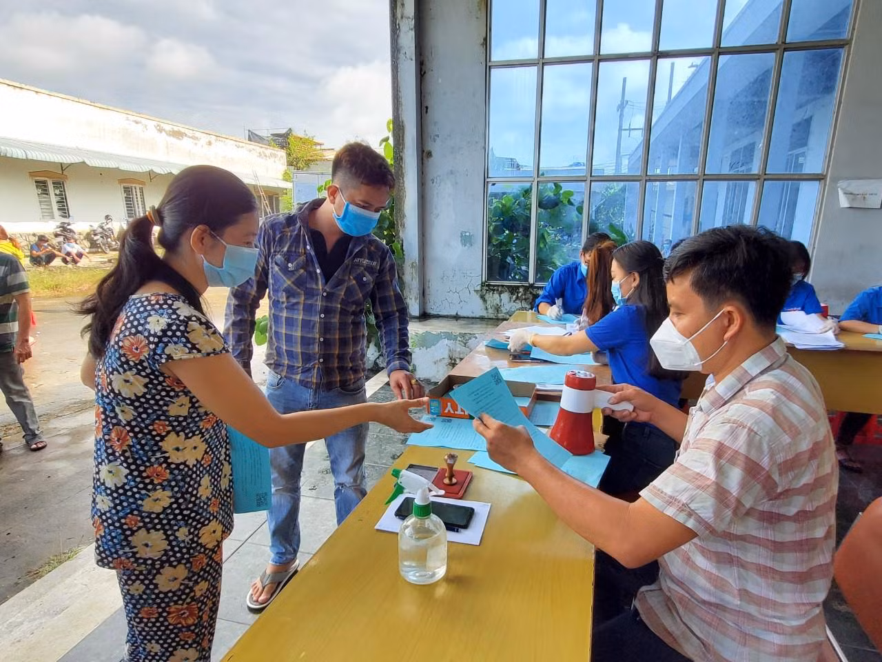 Trả phiếu tiêm chủng cho người dân. Ảnh: Kim Hà.