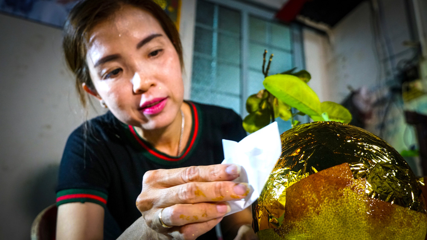 Chị Phước thực hiện thao tác dát vàng lên trái bưởi.