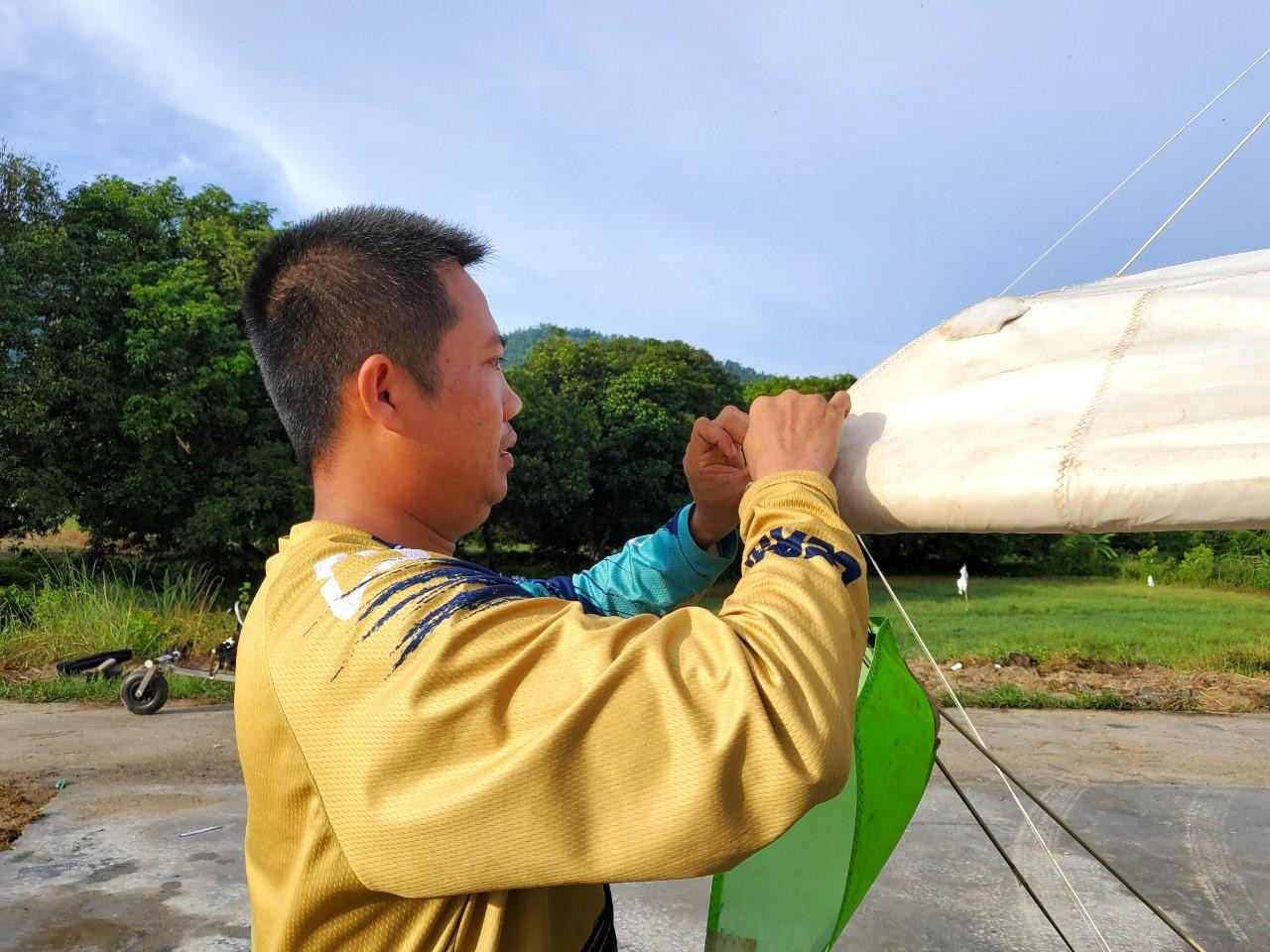 Phi công diều lượn có động cơ đang kiểm tra phương tiện của mình trước khi cất cánh - Ảnh: Kim Hà.