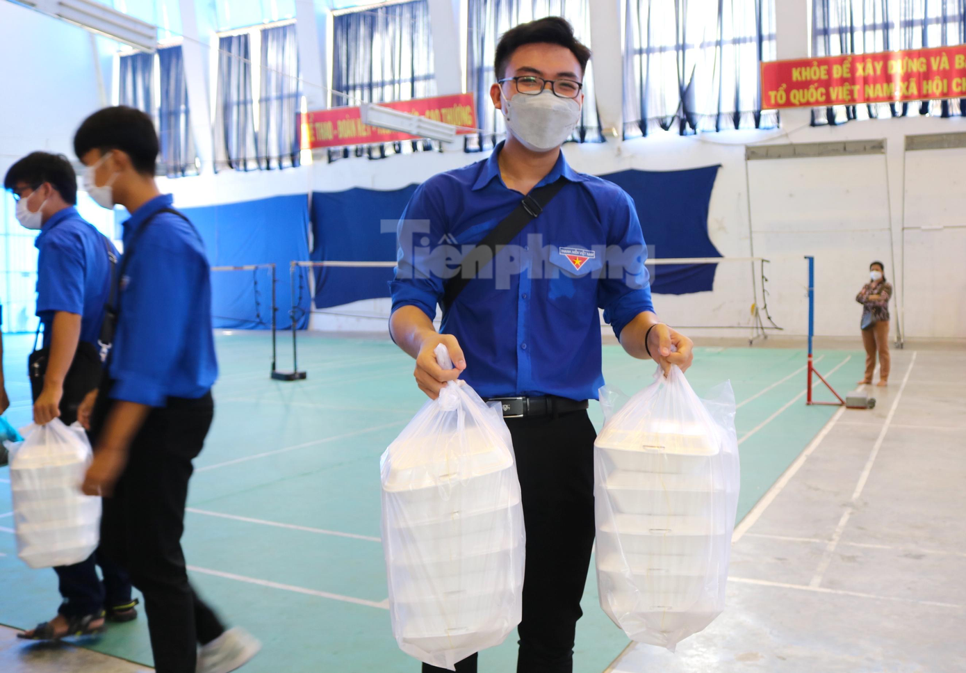 Lực lượng thanh niên tình nguyện hăng hái hỗ trợ vận chuyển suất ăn cho các thí sinh tại điểm thi Trường THPT Bùi Hữu Nghĩa - Ảnh: Kim Hà.