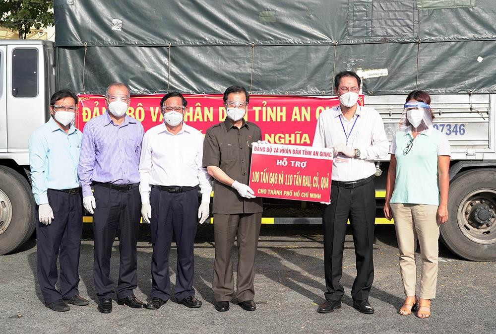 Ông Lê Hồng Quang - Bí thư Tỉnh uỷ An Giang (áo nâu) trao tặng quà cho TP Hồ Chí Minh.