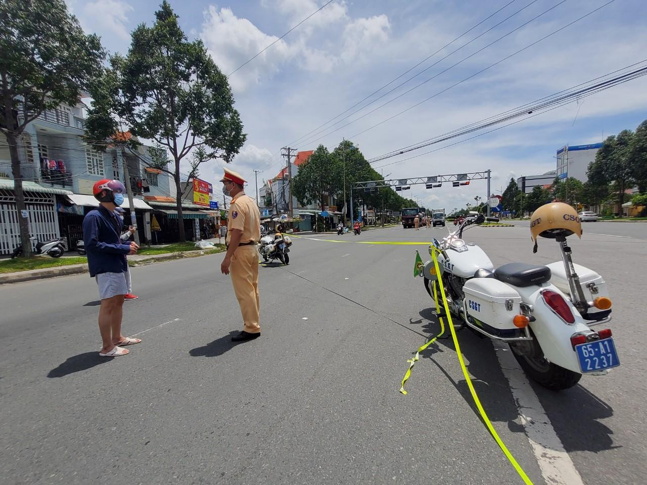 Người dân trình bày lí do ra đường với cán bộ CSGT tại chốt trên đường Võ Văn Kiệt - Ảnh: Kim Hà.