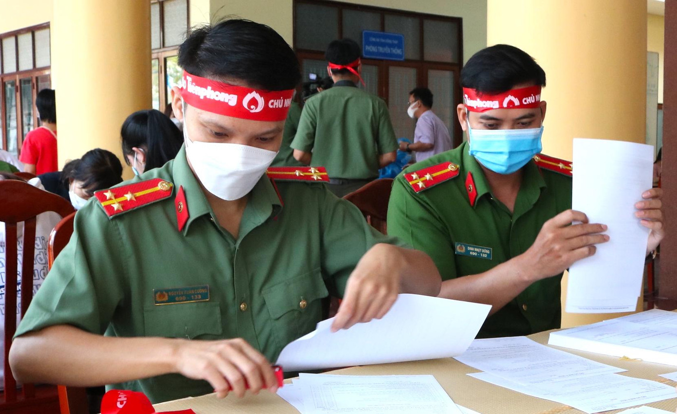 Cán bộ, chiến sĩ hỗ trợ phát phiếu điền thông tin cho tình nguyện viên - Ảnh: Kim Hà.