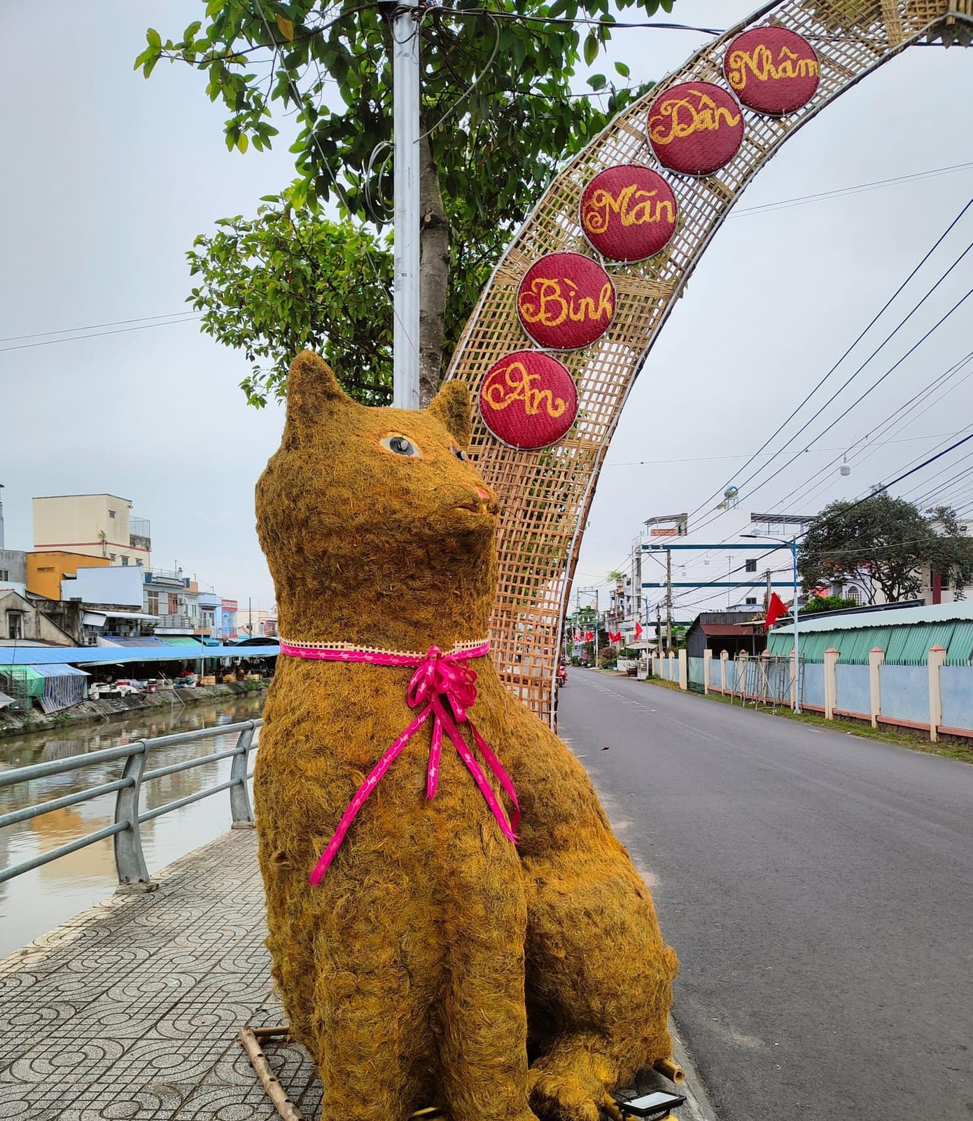 Linh vật mèo Tiền Giang gây chú ý vì được làm bằng rơm rạ, ép, tạo hình đáng yêu. Tuy nhiên, một số người cho rằng khuôn mặt linh vật này giống con chuột hơn là mèo. Chú mèo rơm với khuôn mặt gây tranh cãi này được đặt tại cổng chào gần chợ văn hóa thị trấn Vĩnh Bình, Tiền Giang. Ảnh: Thành Chinh Nguyễn.