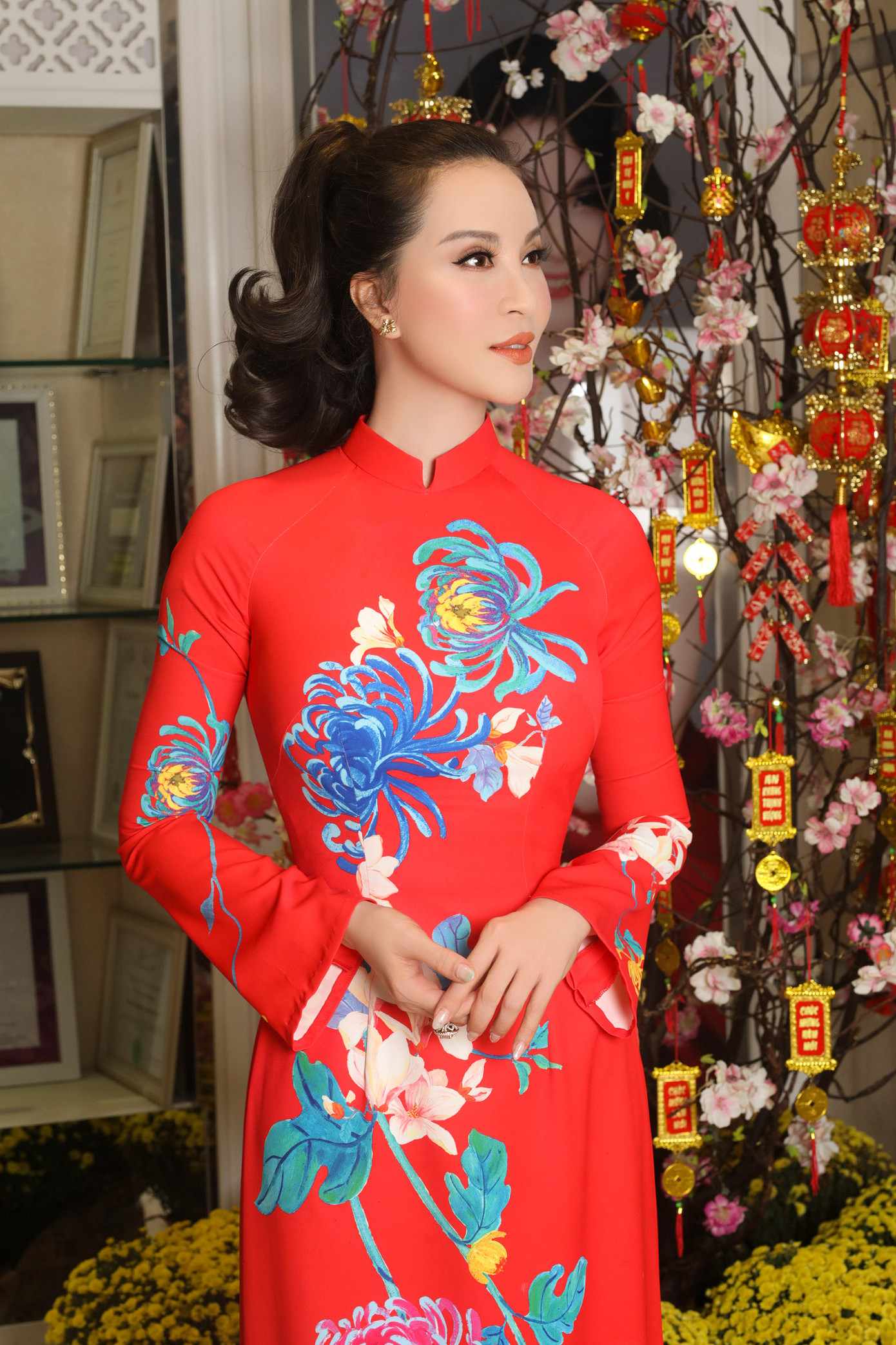 Những ngày cận Tết, MC Thanh Mai diện áo dài nền nã xuống phố. Cô chọn các thiết kế truyền thống, tôn đường cong với họa tiết màu sắc. Để đồng điệu với trang phục, nữ MC trang điểm nhẹ nhàng, mái tóc buộc cao tôn đường nét trên gương mặt.