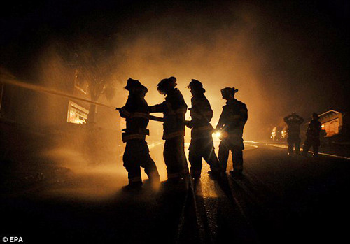 Hàng trăm lính cứu hỏa được huy động để dập tắt đám cháy lan rộng vào sáng sớm khi bầu trời vẫn tối mịt - Ảnh: EPA