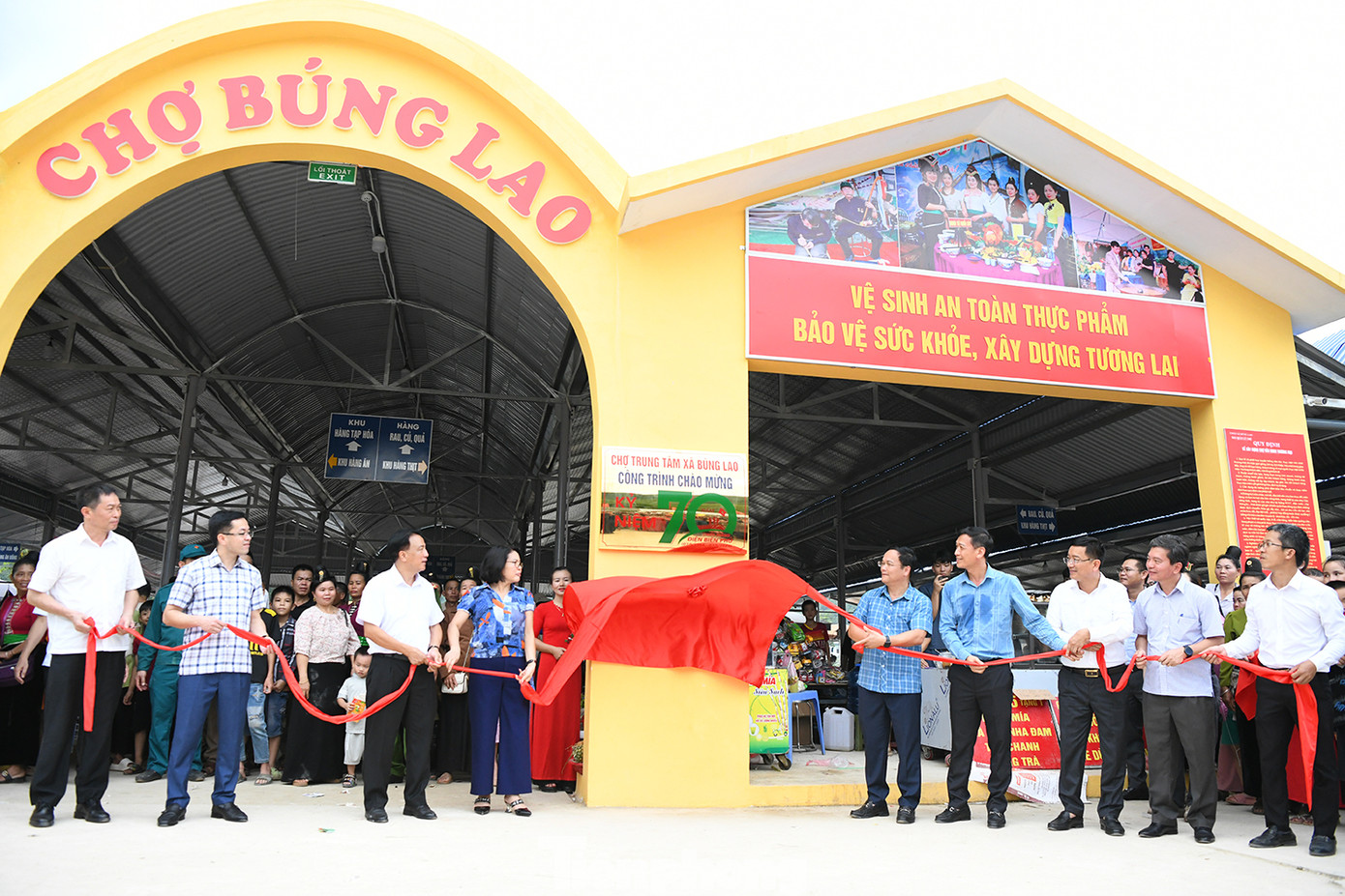 Các đồng chí lãnh đạo huyện Mường Ảng cùng các đại biểu, nhân dân huyện Mường Ảng gắn biển công trình chợ trung tâm xã Búng Lao.