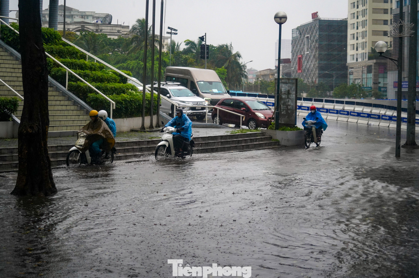 Nhiều xe máy phải &apos;rồng rắn&apos; leo lên vỉa hè để thoát khỏi chỗ ngập sâu.