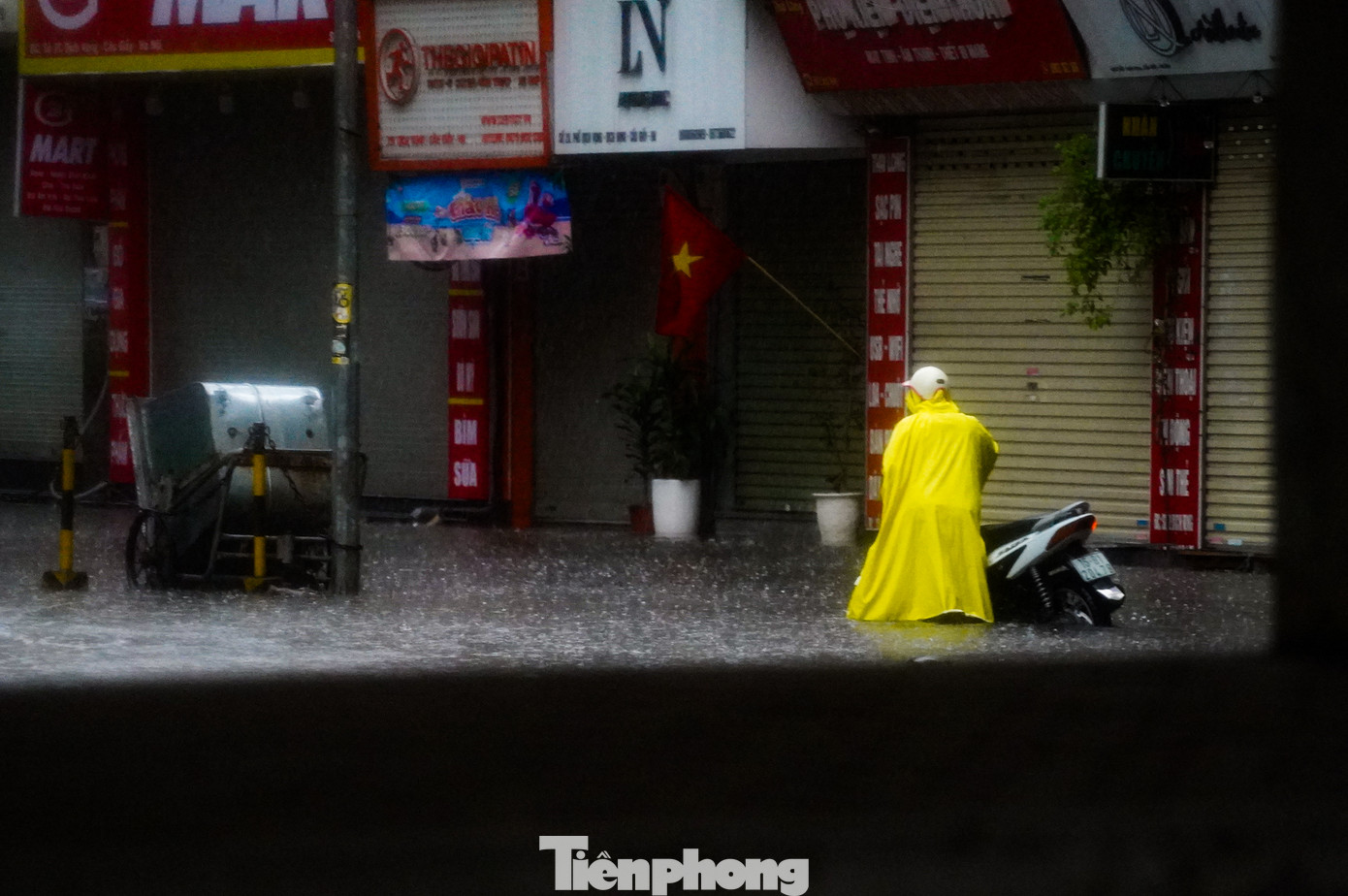 Xe chết máy, người điều khiển phải xuống dắt bộ giữa dòng nước ngập.