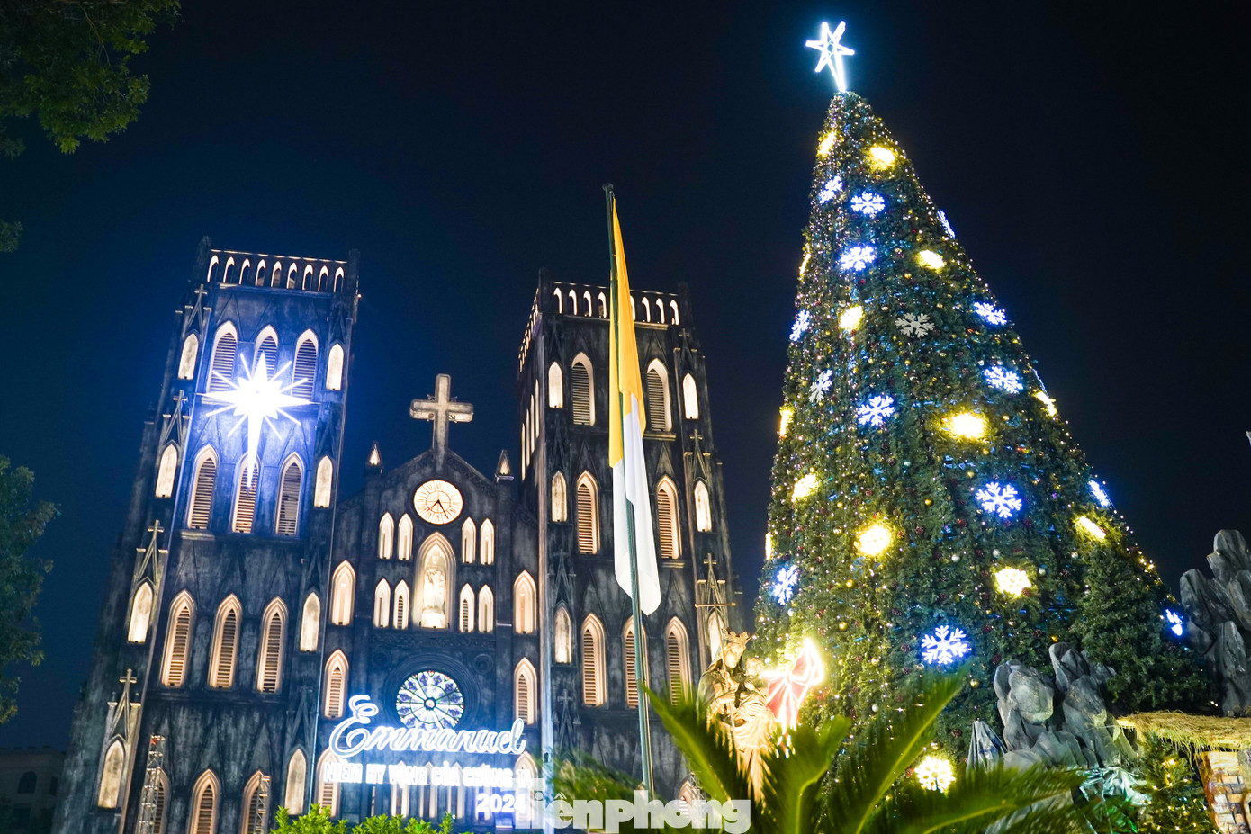 Bên ngoài Nhà thờ Lớn rực rỡ và lung linh sắc màu với cây thông Noel khổng lồ cao 16m được trang trí bằng các vật phẩm quen thuộc như bông tuyết, ngôi sao, đèn điện, dây kim tuyến.... kết hợp cùng với tiểu cảnh hang đá nơi Chúa giáng sinh.