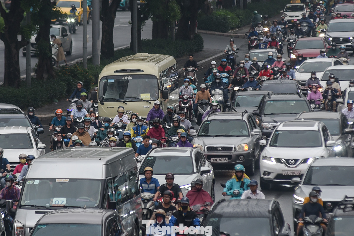 Xe máy và ôtô chen nhau trên đường.