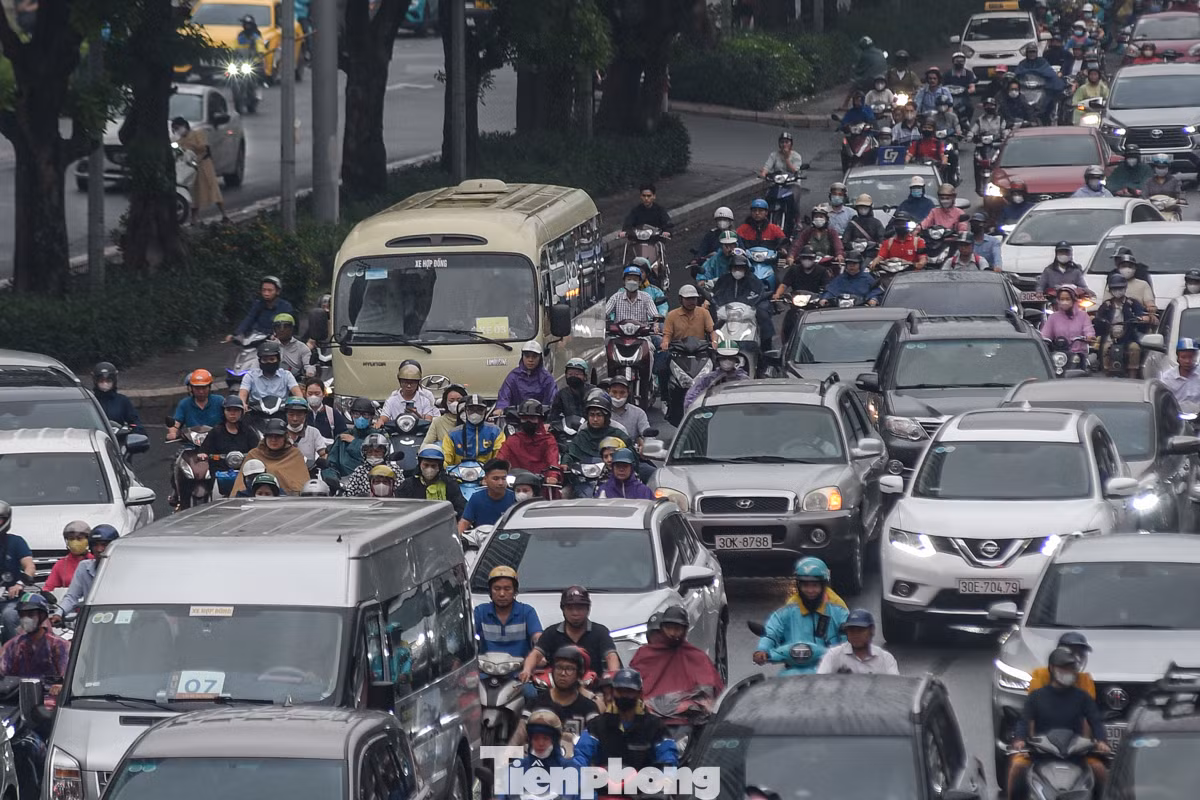 Xe máy và ôtô chen nhau trên đường.