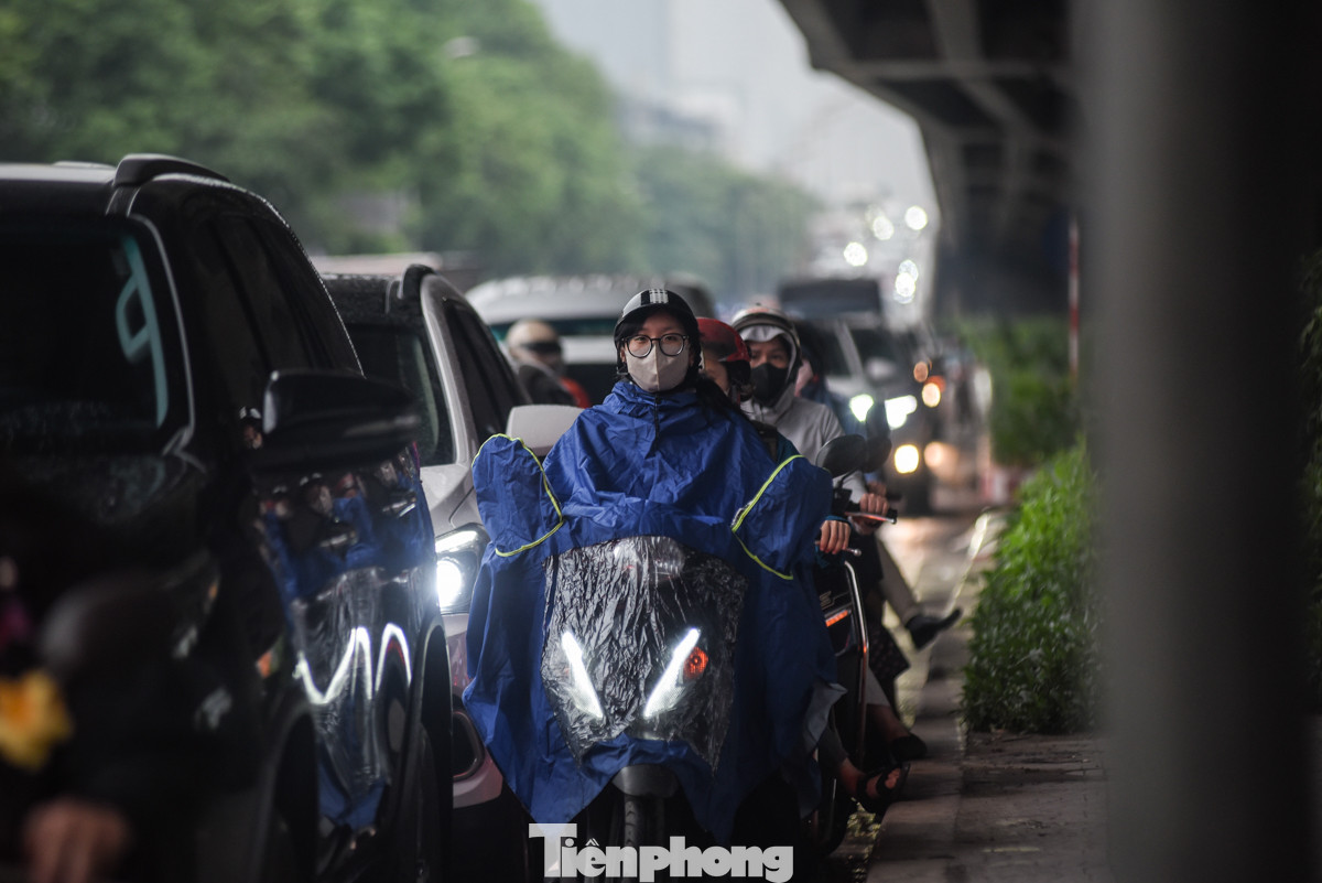 Người điều khiển xe máy cố gắng tìm lối thoát từ các khe hở của xe ôtô trên đường Khuất Duy Tiến.