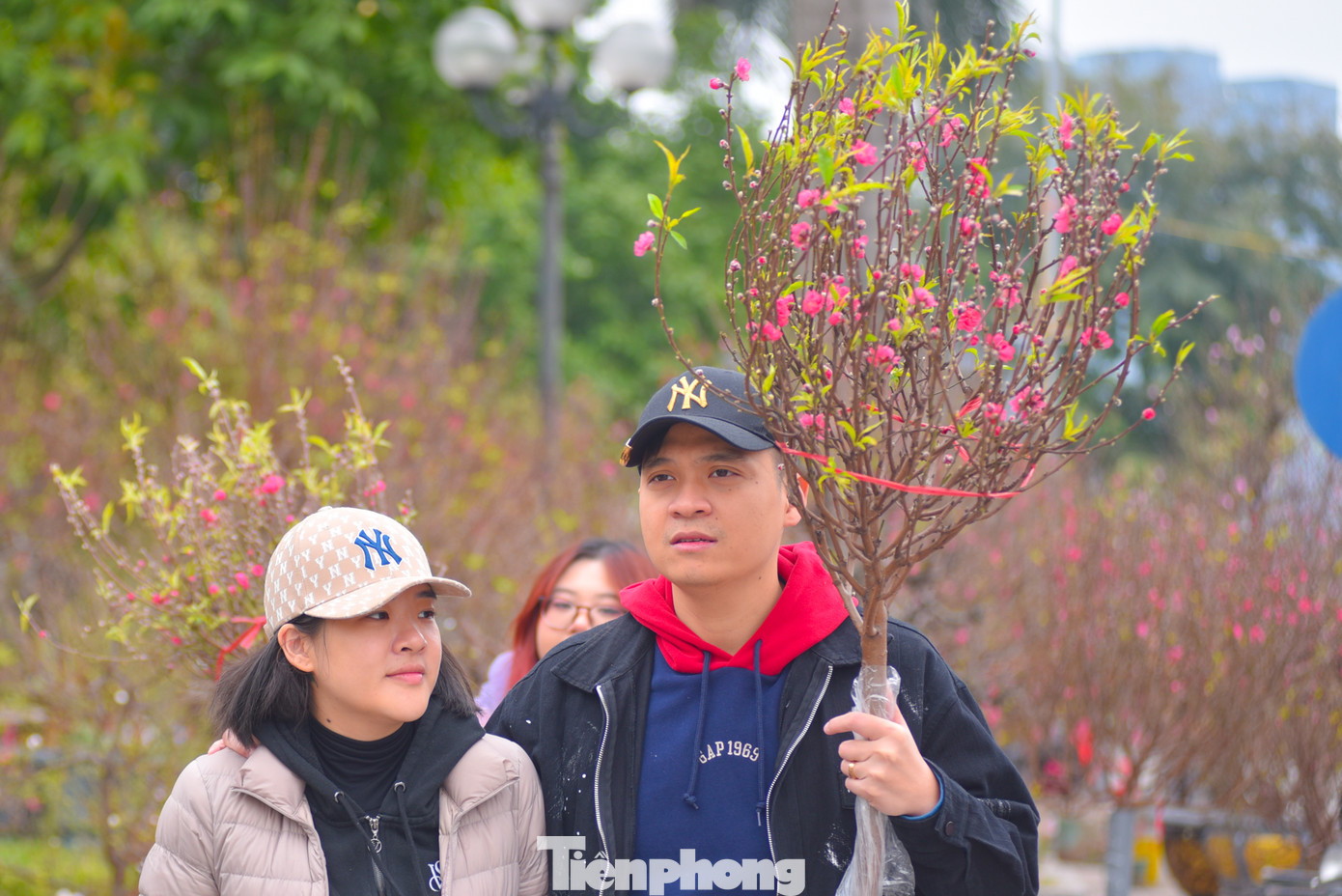 Anh Lê Hữu Vinh chọn mua một cành đào về chơi sớm. "Năm nay kinh tế cũng khó khăn nên tôi chỉ mua cánh đào nhỏ", anh Vinh cho biết.