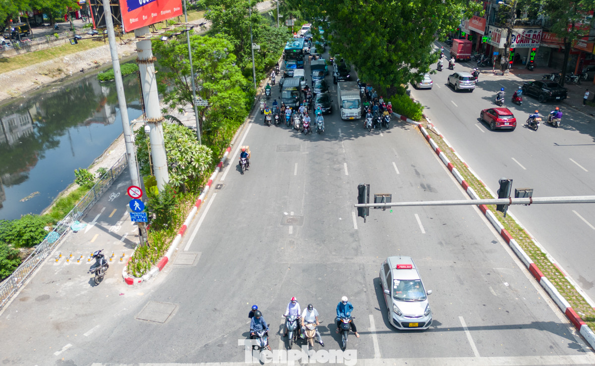 Tại đường Láng, khi dừng đèn đỏ, hàng dài phương tiện "núp" vào nơi có bóng mát để tránh nắng.