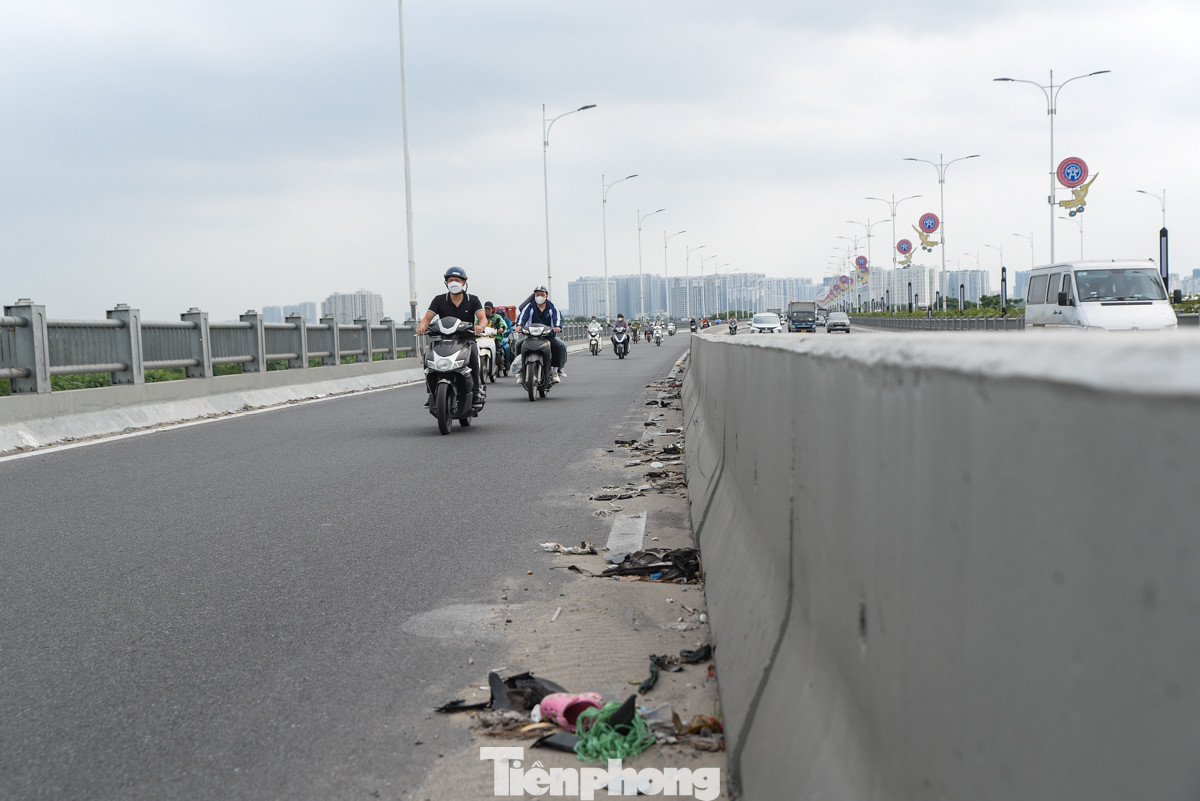 Rác thải sinh hoạt vứt bừa bãi dưới mặt đường, trên lan can cầu Vĩnh Tuy.