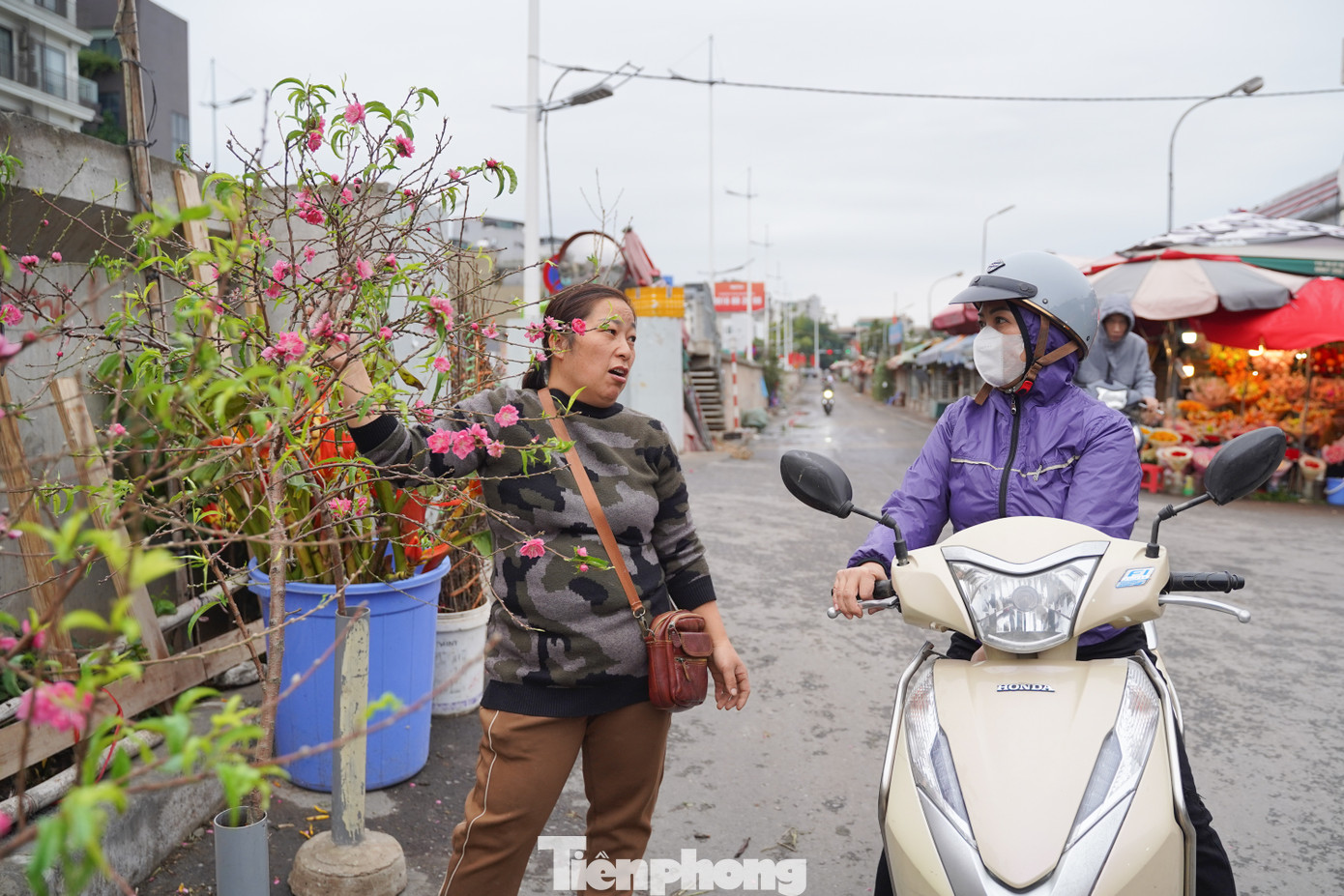 Cô Nguyễn Thị Bích (quận Tây Hồ) đi mua đào để chơi Tết Dương lịch. "Đi qua chợ hoa thấy có đào nở khá đẹp nên tôi đến mua luôn", cô Bích nói.