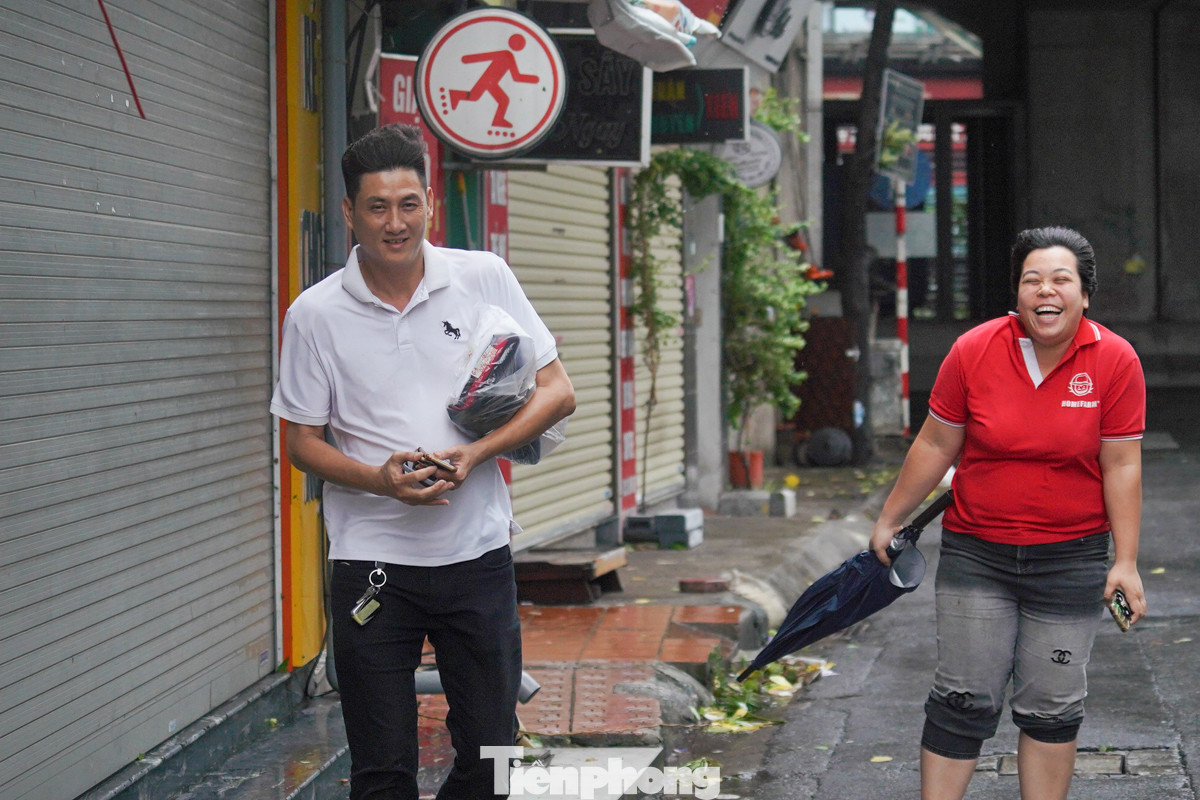 Hai người di chuyển chậm trong cơn gió.