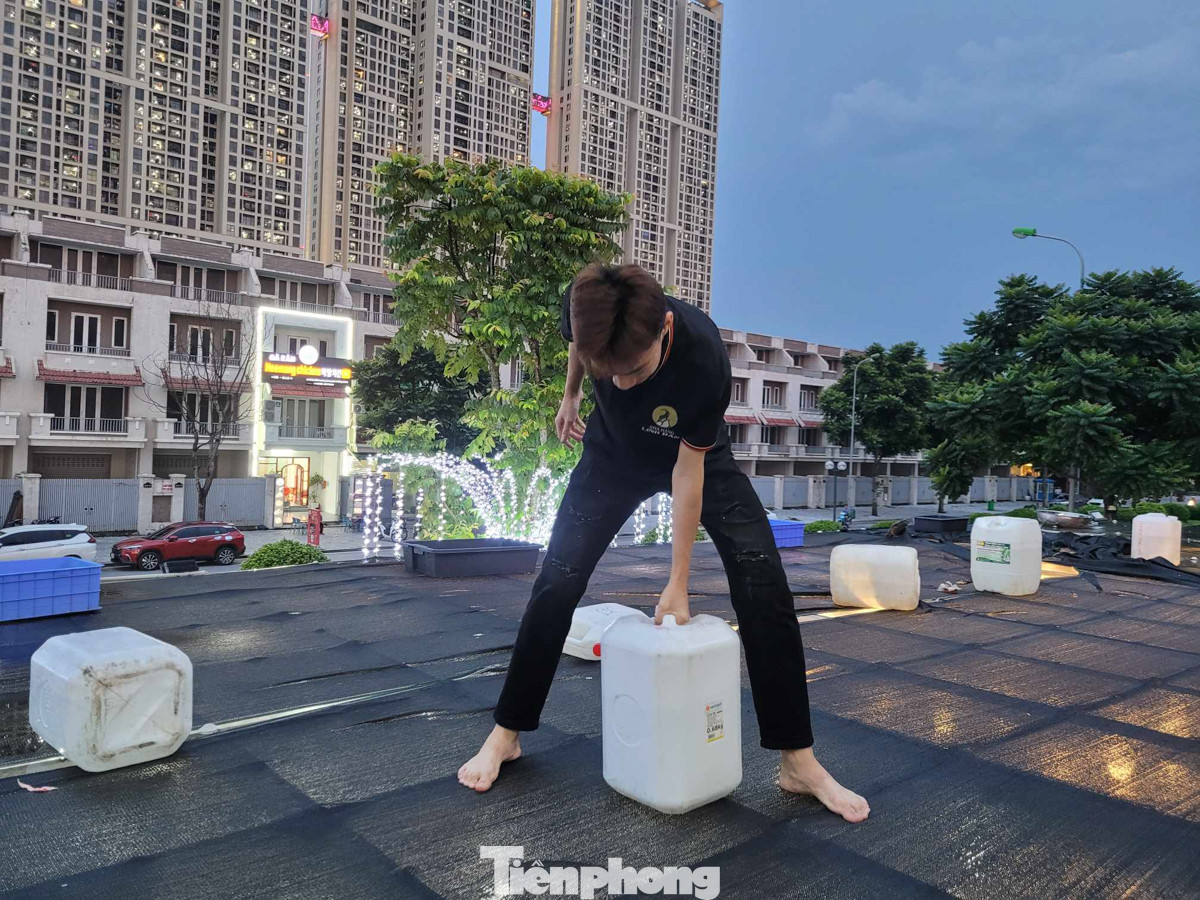 Mái nhà tại khu đô thị An Khánh được người dân gia cố bằng bao cát, đặt thùng nước hoặc bơm nước vào túi nilon rồi đặt lên