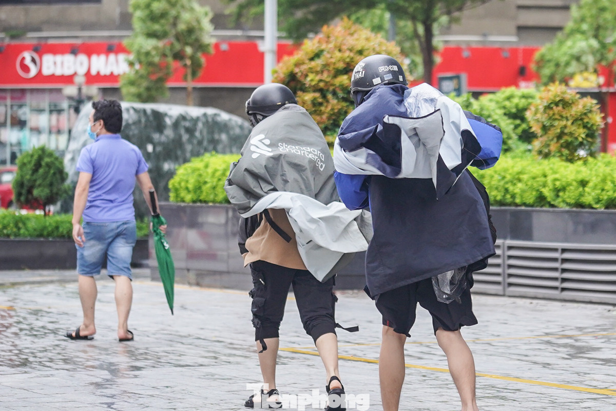 Hai bạn trẻ chới với trong gió, áo mưa bay phần phật.