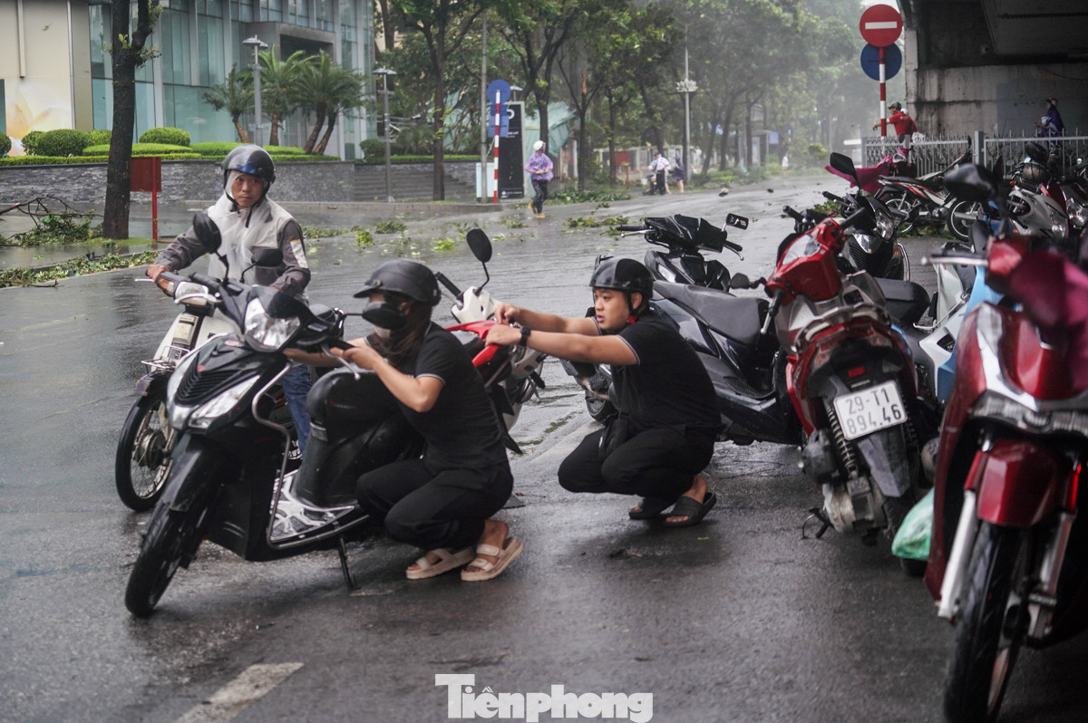 2 người cố di chuyển xe máy đi nhưng không thể.