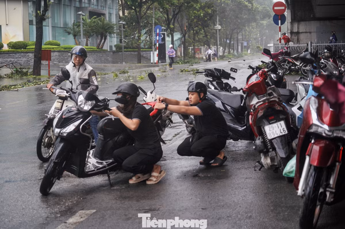 2 người cố di chuyển xe máy đi nhưng không thể.