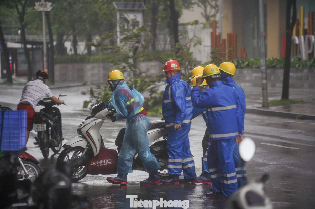 Gió quá mạnh, phải cần đến 6 người mới có thể giúp một chiếc xe di chuyển vào nơi an toàn.