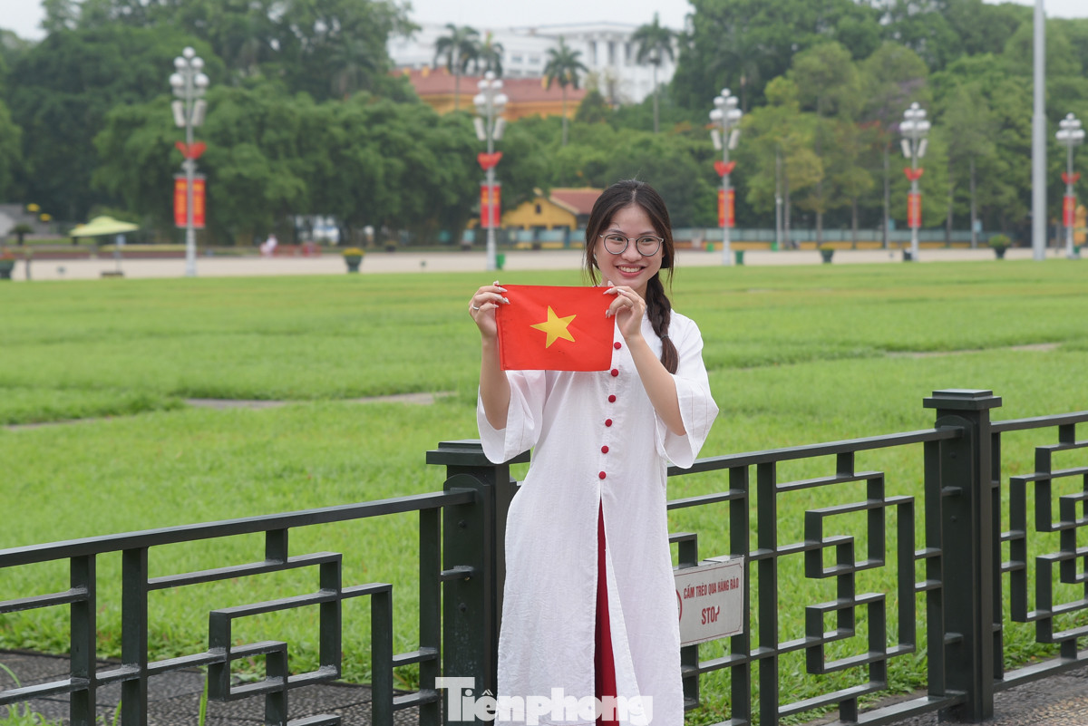 Bạn Đỗ Thu Uyên tự hào cầm trên tay lá cờ Tổ quốc chụp ảnh trước Quảng trường Ba Đình.