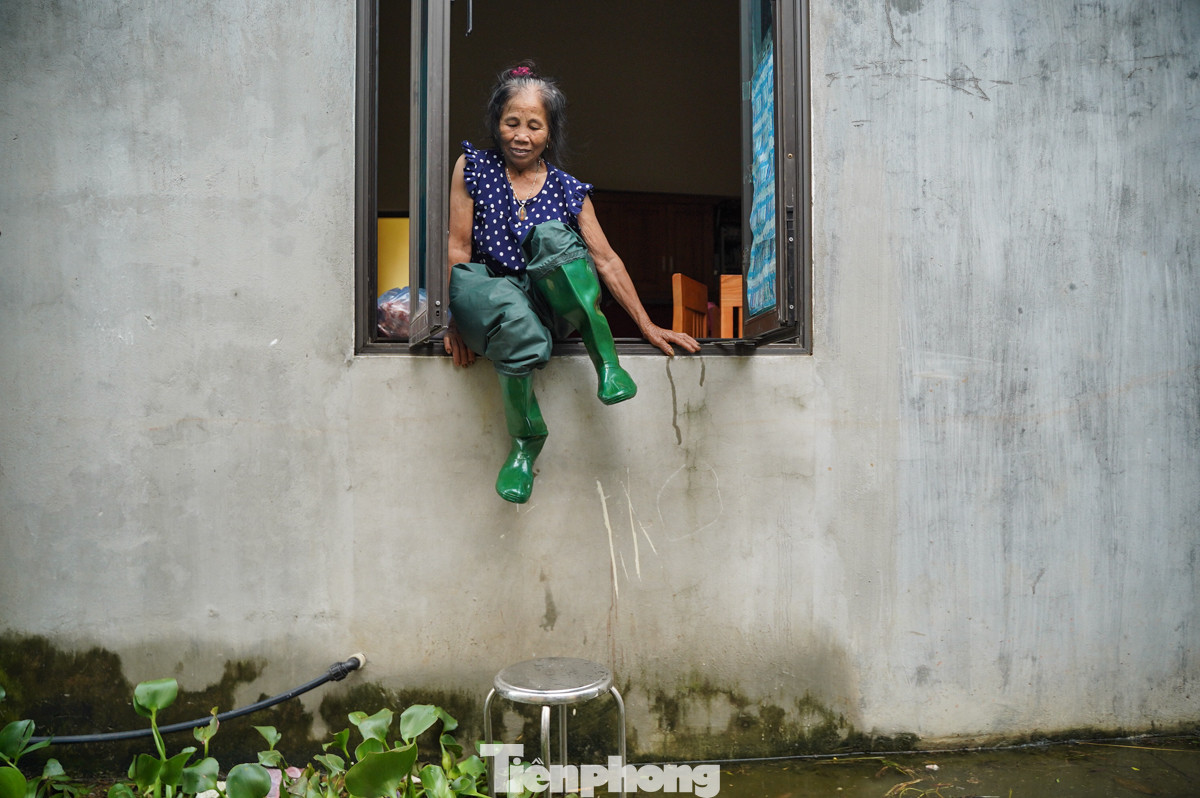 Cổng vào nhà nước ngập hơn 1 mét trong nước nên nhiều hộ phải phải leo cửa sổ khi cần ra ngoài.