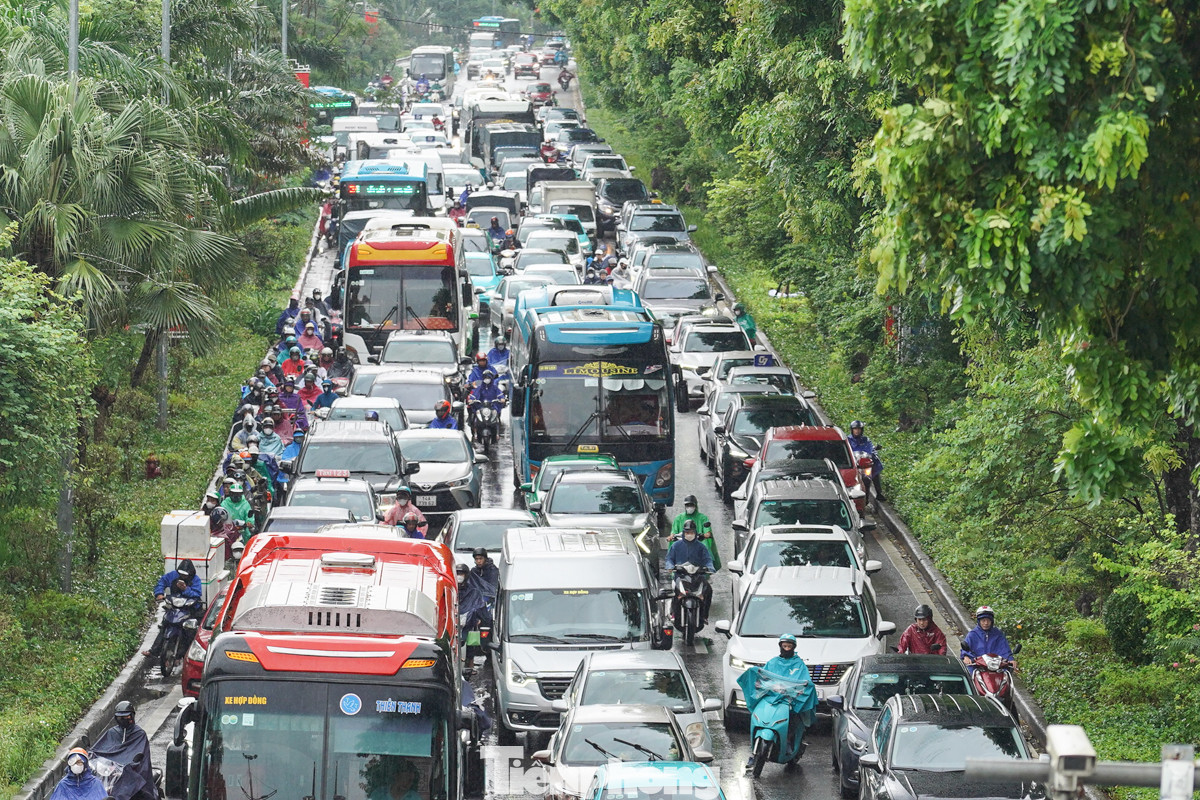 Tại đường Láng lúc hơn 10 giờ, dòng phương tiện ken đặc di chuyển dưới mưa, xe máy và ôtô chen nhau để di chuyển. Tại đường Láng lúc hơn 10 giờ, dòng phương tiện ken đặc di chuyển dưới mưa, xe máy và ôtô chen nhau để di chuyển.