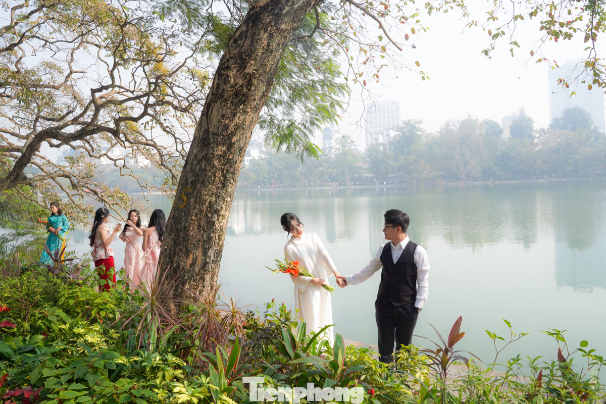 Quanh bờ hồ, rất đông 'nàng thơ' và các cặp đôi tạo dáng chụp ảnh.