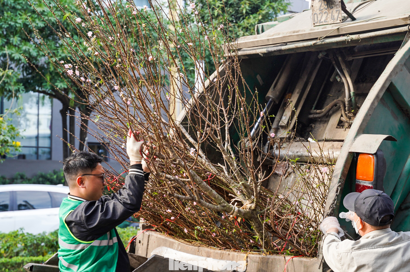 Các công nhân môi trường dọn đào do tiểu thương bỏ lại trên vỉa hè chiều 29 Tết.