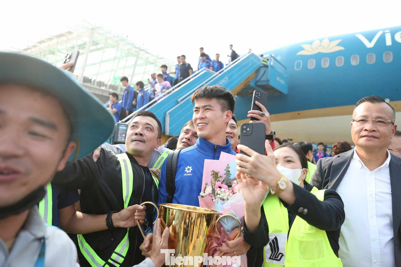 Duy Mạnh và HLV Kim Sang-sik rước cúp.