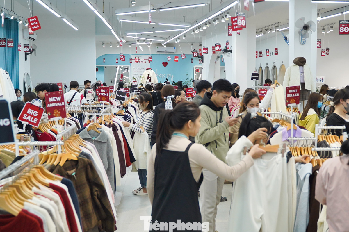 Các cửa hàng quần áo dọc phố Cầu Giấy vào buổi tối có rất đông người đến mua sắm, chủ yếu là giới trẻ. Nhiều cửa hàng có chương trình giảm giá lên đến 80%.