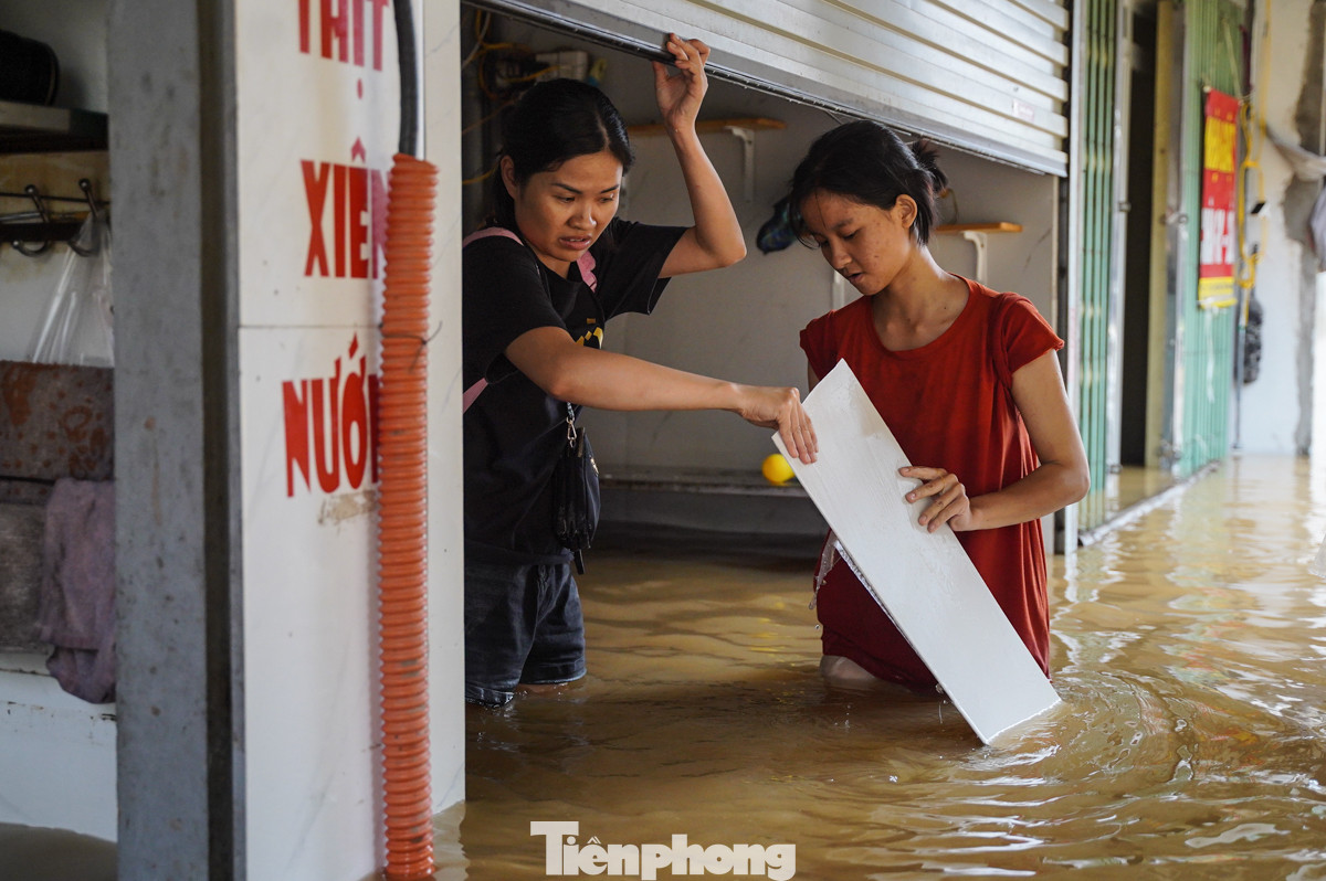 "Kinh hoàng, sáng ngủ dậy nhìn ra đường chỉ thấy nước. Chúng tôi đang cố gắng dọn dẹp, đưa đồ lên cao để về quê tránh lũ", chị Linh chia sẻ.
