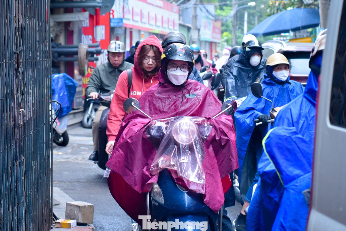 Mưa nhỏ nhưng lạnh buốt, dòng phương tiện đông đúc di chuyển từng chút một.