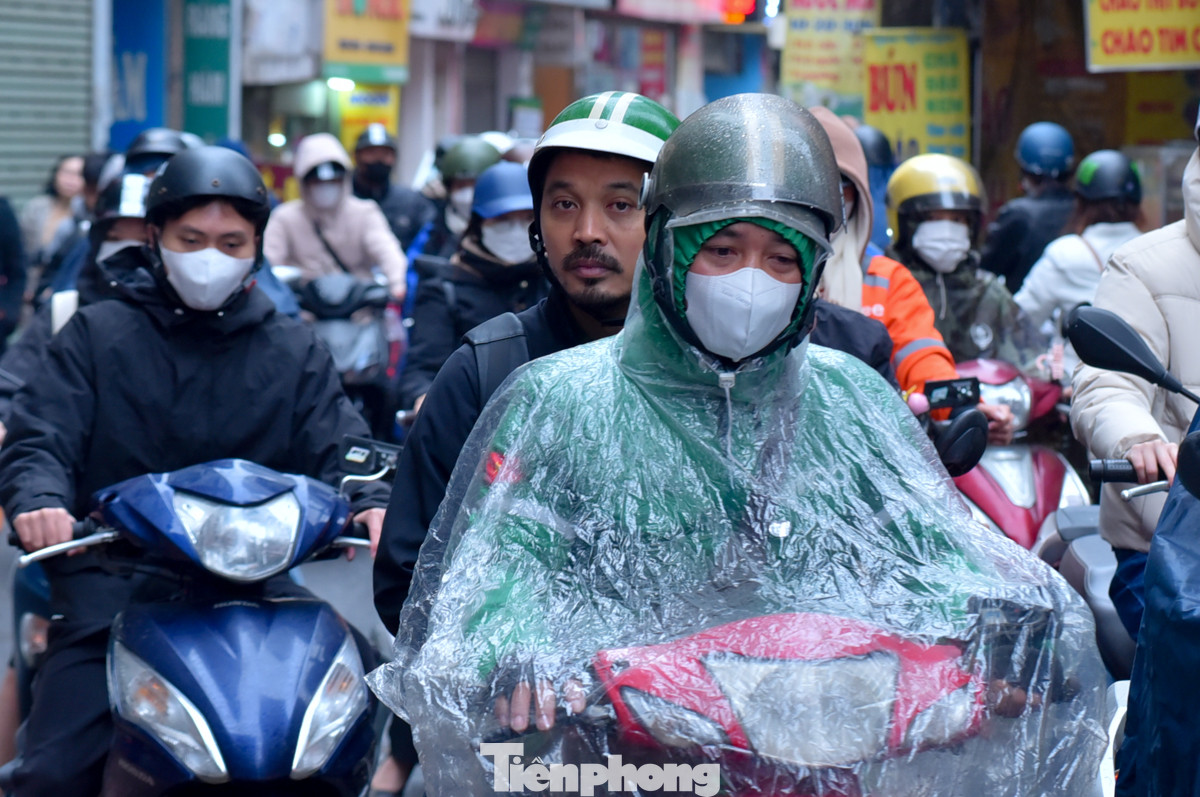 Mưa nhỏ nhưng lạnh buốt, dòng phương tiện đông đúc di chuyển từng chút một.
