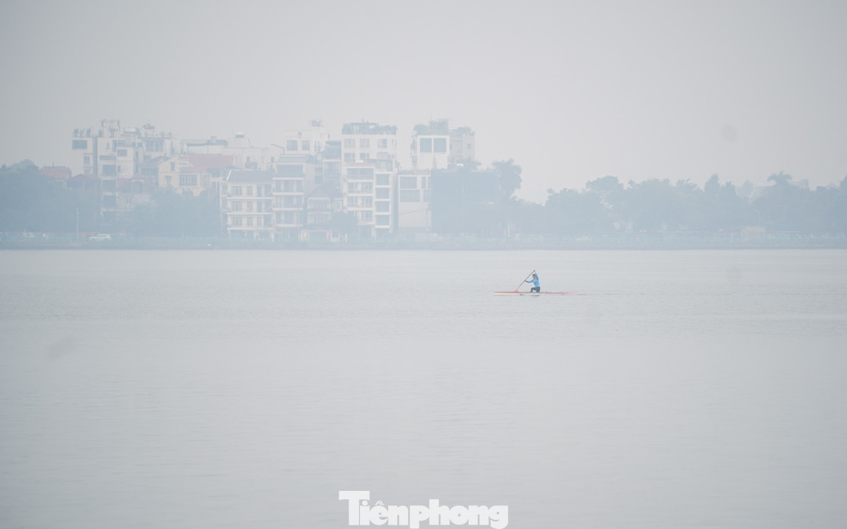 Đường ven Hồ Tây 7h30 vẫn mờ mịt trong lớp sương dày, chưa thấy bóng mặt trời. Người dân đi tập thể dục phải đeo khẩu trang để bảo vệ sức khỏe.