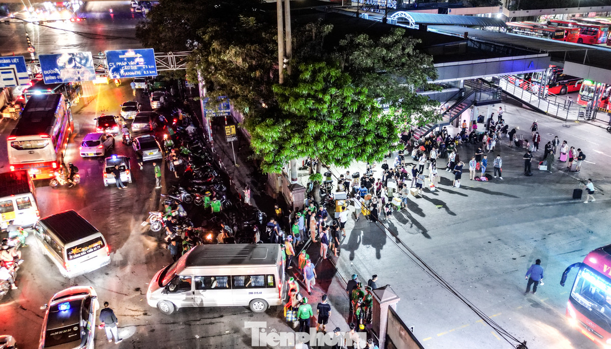 Tại bến xe Nước Ngầm thời điểm khoảng hơn 4 giờ sáng, hàng chục xe taxi, xe ôm công nghệ và truyền thống đỗ kín mặt đường Ngọc Hồi đoạn trước cổng bến xe để chờ đón khách.