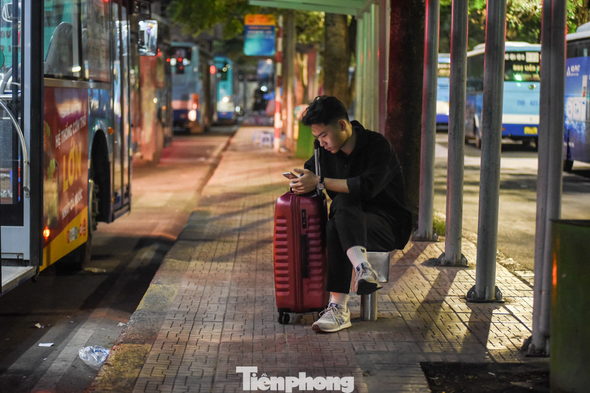 Nhiều người dân ngồi đợi xe buýt đến giờ chạy.