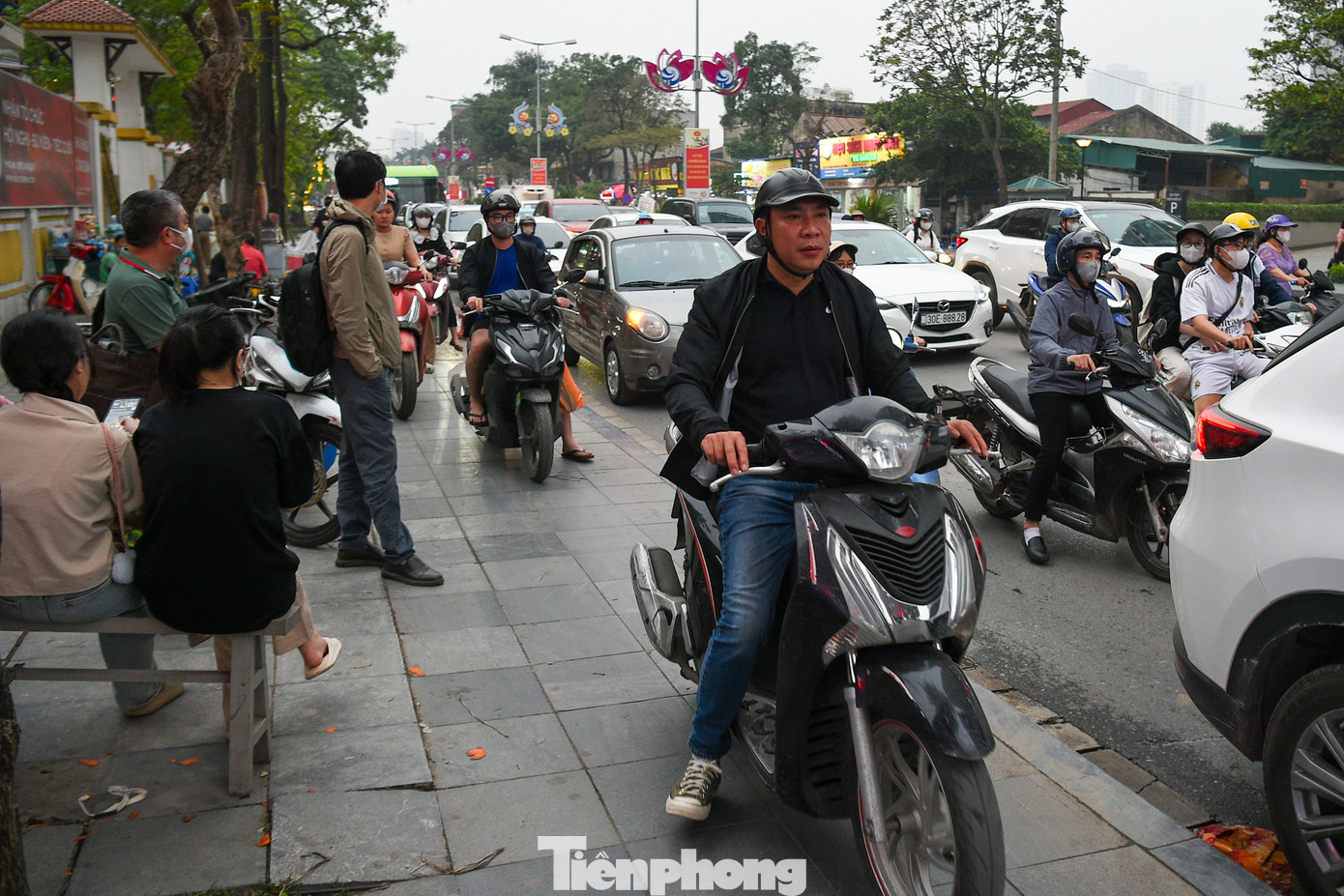 Lúc 18h, nhiều chủ phương tiện phải leo lên vỉa hè như “làn khẩn cấp”, lối đi của toà nhà hòng thoát khỏi cảnh tắc đường.